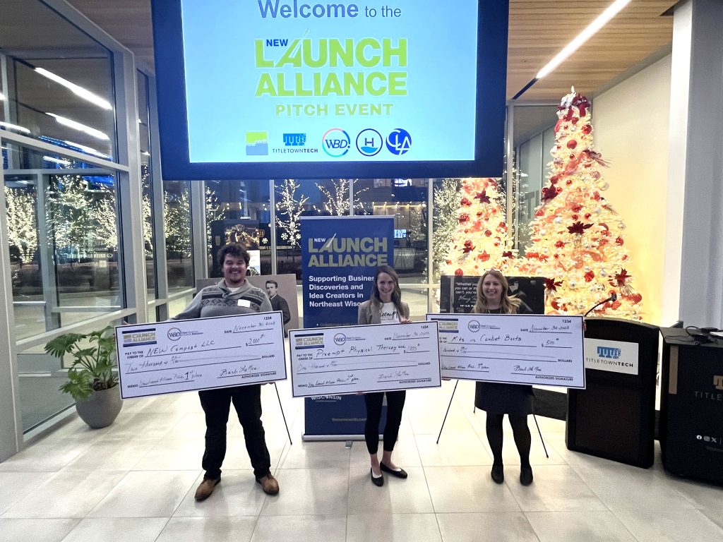 Three people holding oversized checks